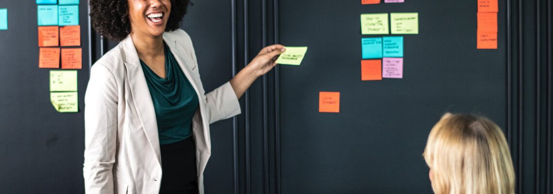 Woman putting post-it notes on wall.